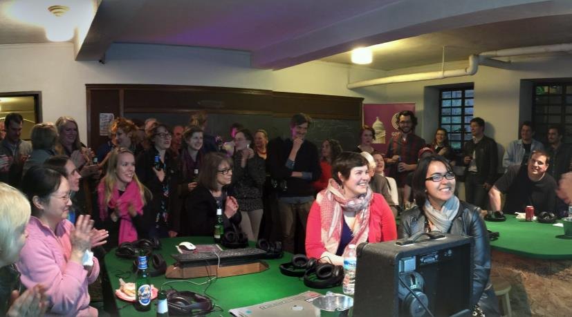 An audience gathered around a screen at the Happy Hour preview party