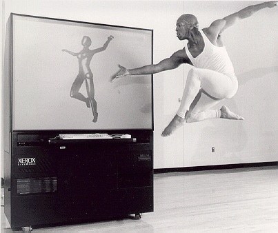 Boris Willis leaping beside a screen rendering a digital figure